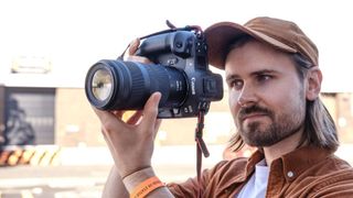 Man holding Canon camera with lens up to his face